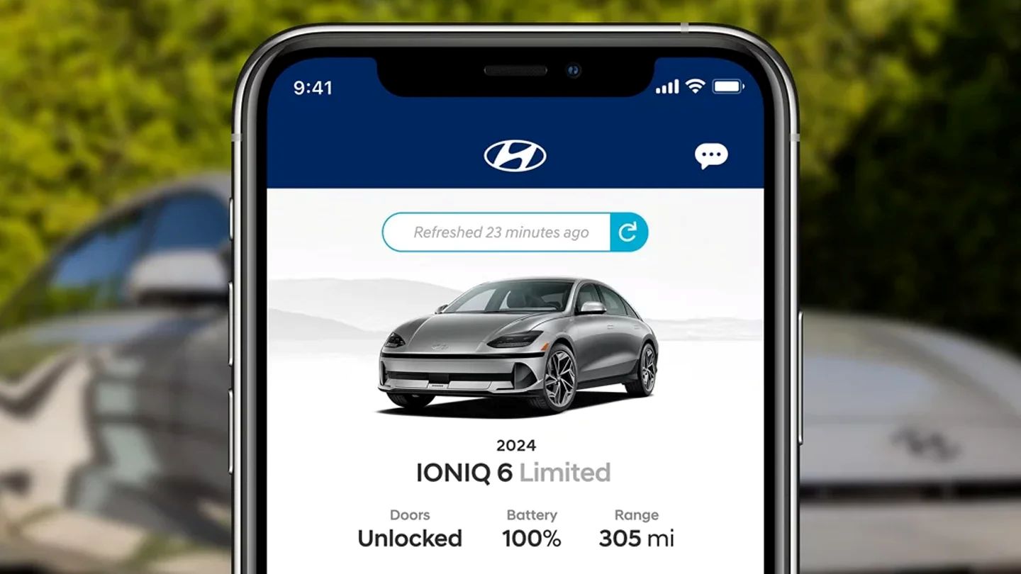 Phone showing BlueLink app in front of Hyundai car parked in driveway