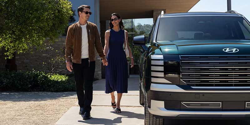 2026 Hyundai Palisade SUV parked outside with passengers walking nearby