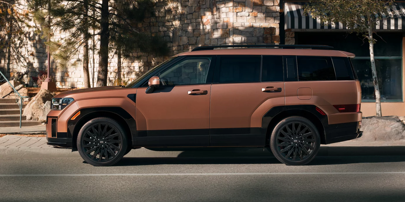 Bronze 2026 Hyundai Sante Fe SUV parked on a city street near Jerry V’s Honolulu Hyundai dealership.