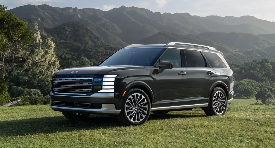 2026 Hyundai Palisade Hybrid parked in a scenic mountain landscape, showcasing its modern design and bold front grille.