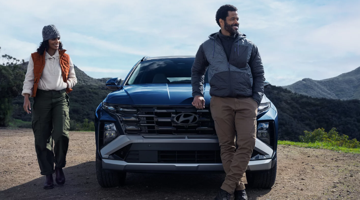 2026 Hyundai Tucson parked on a scenic dirt overlook as two people stand beside the SUV.