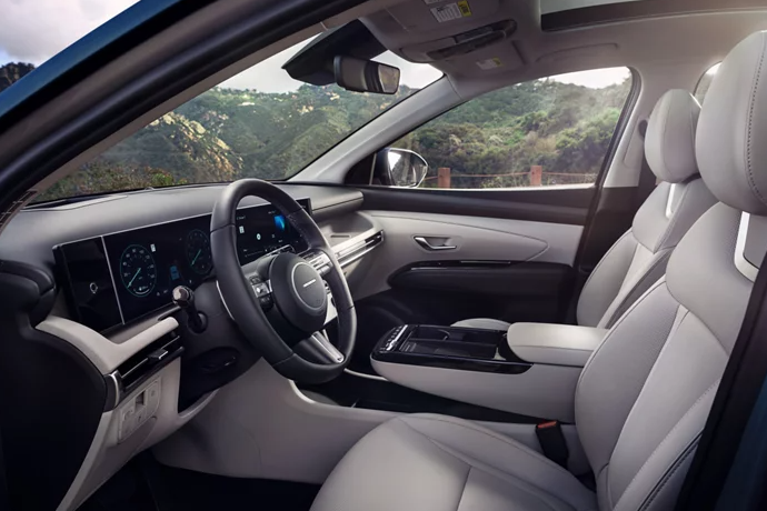 2026 Hyundai Tucson interior featuring a modern dashboard, digital displays, and light-colored leather seating.